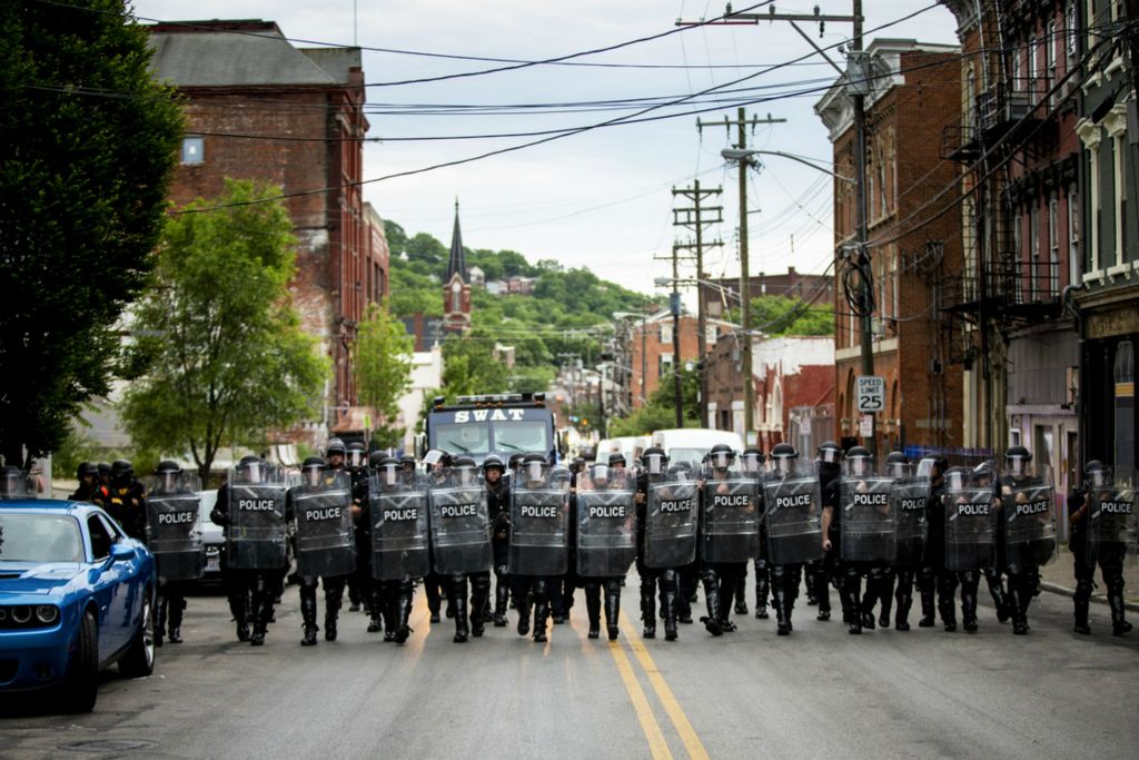 Award of Excellence, News Picture Story - Meg Vogel / The Cincinnati Enquirer, “BLM Protest”Cincinnati Police officers walk in formation on McMicken Street in Over-the-Rhine after the 8 p.m. curfew on Monday, June 1, 2020. This was the fourth night of protests in response to the death of George Floyd in Minneapolis. When it was past the 8 p.m. curfew,  protesters ran to avoid getting arrested, but many were caught and detained. They sat on the sidewalk with their hands zip-tied behind their backs, waiting to be processed and transported. 