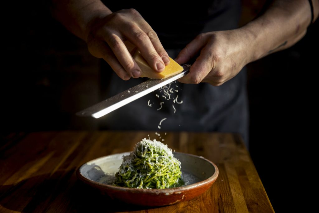 First Place, Product Illustration - Meg Vogel / The Cincinnati Enquirer, “Baker’s Table”Chef Josh Helms grates Pecorino cheese over the whole wheat tonnarelli with rapini pesto at The Baker's Table in Newport, Kentucky. 