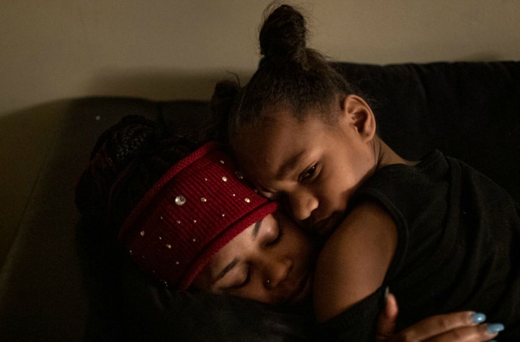 First Place, George S. Smallsreed Jr. Photographer of the Year - Large Market - Meg Vogel / The Cincinnati EnquirerAmariyonna, 9, hugs her mom Page Berry before Berry leaves her Westwood apartment to go to work moving freight on a rainy airport tarmac on Wednesday, February 26, 2020.  Page is working with Legal Aid to fight her eviction. She has been evicted before, years ago, and never forgot what it was like to be without a home. She now keeps a mental checklist of where she and the girls might go if it happened again. It’s why she usually makes the car payment a top priority. If they have to, they can always sleep in the Camry.