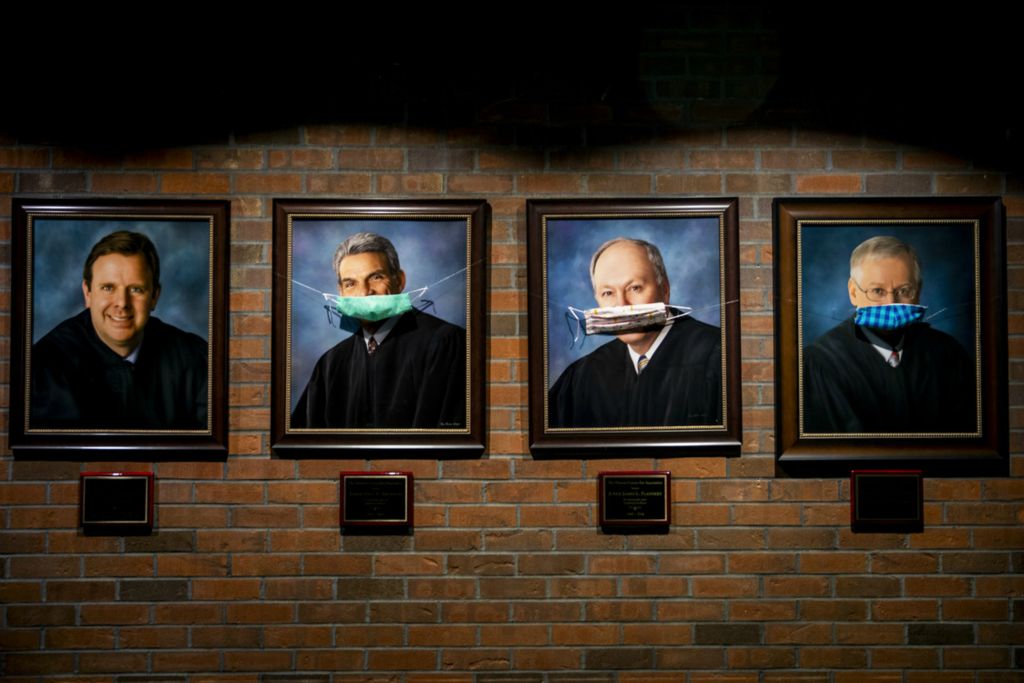 First Place, George S. Smallsreed Jr. Photographer of the Year - Large Market - Meg Vogel / The Cincinnati EnquirerPortraits of judges are adorned with homemade masks at Warren Commons Pleas Court in Lebanon on Thursday, April 16, 2020. 