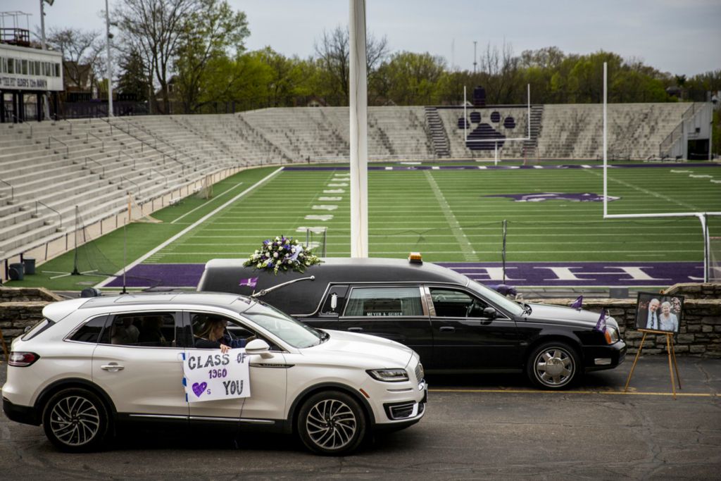 First Place, George S. Smallsreed Jr. Photographer of the Year - Large Market - Meg Vogel / The Cincinnati EnquirerA procession of vehicles passes the hearse carrying Bob James in front of Elder High School on Tuesday, April 14, 2020, in West Price Hill. James, 77, died on April 6, 2020. His family could not have a funeral because of the pandemic and arranged for a drive-thru visitation and parade to honor his life. James graduated from Elder in 1960.  Craig James, his son, said, "He wanted to be able to pass by Elder on his way home."  Hundreds of cars drove to pay their final respects. Dozens of businesses along the route honored James with signs. The James family has been heavily involved at Elder and in their athletic program for decades.