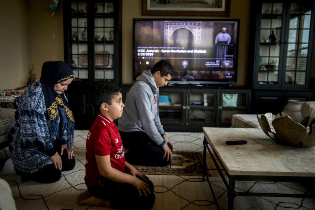 First Place, George S. Smallsreed Jr. Photographer of the Year - Large Market - Meg Vogel / The Cincinnati EnquirerNoha Eyada prays with her children Yahia, 19, and Yusuf, 8, at their home in Mason after watching the call to prayer from the Islamic Center of Greater Cincinnati in West Chester on Friday, March 20, 2020. The mosque is closed due to the pandemic. 
