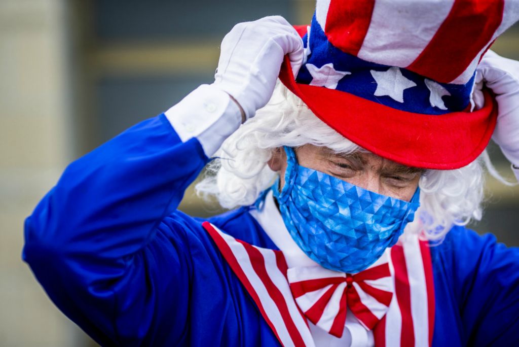 First Place, George S. Smallsreed Jr. Photographer of the Year - Large Market - Meg Vogel / The Cincinnati EnquirerRick Smith, a precinct official, fixes his Uncle Sam hat outside the Warren County Board of Elections in Lebanon, Ohio on Tuesday, April 28, 2020. 