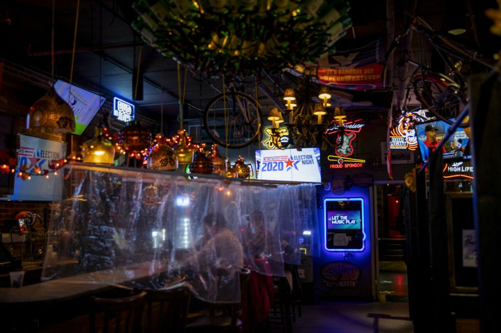 First Place, George S. Smallsreed Jr. Photographer of the Year - Large Market - Meg Vogel / The Cincinnati EnquirerPatrons at The Blind Pig watch the results of election at the bar between sheets of plastic in downtown Cincinnati on Tuesday, November 3, 2020. 