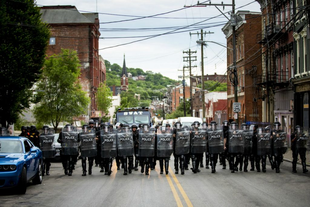 First Place, George S. Smallsreed Jr. Photographer of the Year - Large Market - Meg Vogel / The Cincinnati EnquirerCincinnati Police officers walk in formation on McMicken Street in Over-the-Rhine after the 8 p.m. curfew on Monday, June 1, 2020. This was the fourth night of protests in response to the death of George Floyd in Minneapolis. When it was past the 8 p.m. curfew,  protesters ran to avoid getting arrested, but many were caught and detained. They sat on the sidewalk with their hands zip-tied behind their backs, waiting to be processed and transported. 