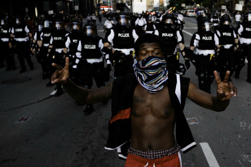 Second Place, George S. Smallsreed Jr. Photographer of the Year - Large Market - Joshua A. Bickel / The Columbus DispatchSTORY SUMMARY: Following the police killing of George Floyd in Minneapolis, protests erupted across the globe calling for an end to police brutality and racial justice. In Columbus, Ohio, protesters came downtown in the days after Floyd’s death, pleading for accountability and demanding change from the local police department, which has had several police-involved shootings of Black men. Tear gas and flash-bangs were common in the first few days of the protests as police attempted to disperse crowds from the streets. The crowds continued to grow and remained largely peaceful in the weeks that followed as protesters worked for change.CAPTION: A protester walks down Broad Street as Columbus Division of Police officers walk behind during nationwide protests following the death of George Floyd on Friday, May 29, 2020 in Columbus, Ohio. Floyd, a 46-year-old Black man, was killed while in police custody after allegedly passing a counterfeit $20 bill at a convenience store. Derek Chauvin, one of four Minneapolis police officers involved in Floyd's arrest, has himself been arrested and charged with third-degree murder and manslaughter. During the arrest, video footage showed Chauvin kneeling on Floyd's neck for almost nine minutes as Floyd repeatedly said "I can't breathe."