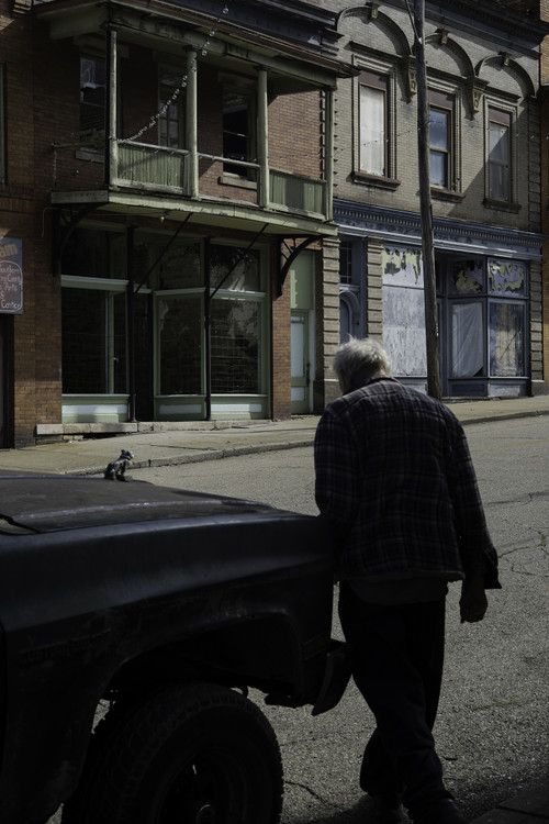 Second Place, George S. Smallsreed Jr. Photographer of the Year - Large Market - Joshua A. Bickel / The Columbus DispatchSTORY SUMMARY: Little cities across southeastern Ohio owe their existence to coal. As the industry boomed in the 19th century, jobs, people and wealth poured into the region. But as coal declined, so did the fortunes of these places. Now, Ohio towns that relied on coal are trying to reinvent themselves as centers of tourism and culture. With coal production levels at their lowest since 1979, residents were largely receptive to campaign promises from President Donald Trump, who in 2016 made promises of a revitalized coal industry a fixture of his stump speech. But coal production levels continued on a steady decline, even during the Trump administration, and the incoming Biden administration plans to pivot to zero-emission electricity by 2035. Long described as a region of poverty and environmental damage, but also of risk-takers and pioneers, residents of Appalachian Ohio both embrace their coal legacy and recognize its effects on the area.CAPTION: A man walks to his truck parked along Main Street on Friday, Sept. 18, 2020 in Shawnee, Ohio. The town, in Appalachian Perry County, was once a bustling coal mining town with a population of nearly 4,000. In 2010, the population stood at 665, according to the U.S. Census. Many buildings are in disrepair, and few economic opportunities remain. “It looks like a Wild West town that’s been dropped in a forest in the east,” said resident Richard Lutz. Despite the town’s struggles, a dedicated group of town citizens are working to reinvent Shawnee as a hub for tourism.