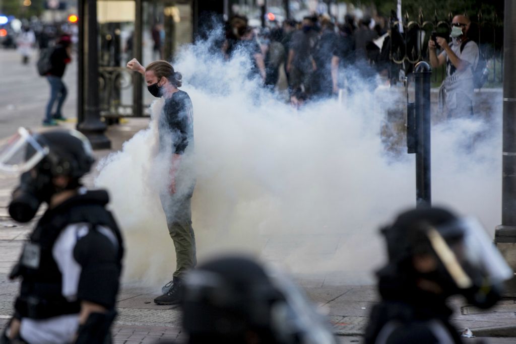 First Place, George S. Smallsreed Jr. Photographer of the Year - Small Market - Jessica Phelps / Newark AdvocateA man holds his ground with his fist in the air as tear gas and Columbus police officers dressed in riot gear try to push back protestors at a Black Lives Matter rally on May 31, 2020. Police and rioters clashed throughout the day as tear gas and rubber bullets were shot indiscriminately into crowds of largely peaceful protestors protesting the death of George Floyd, Breonna Taylor and police brutality. 