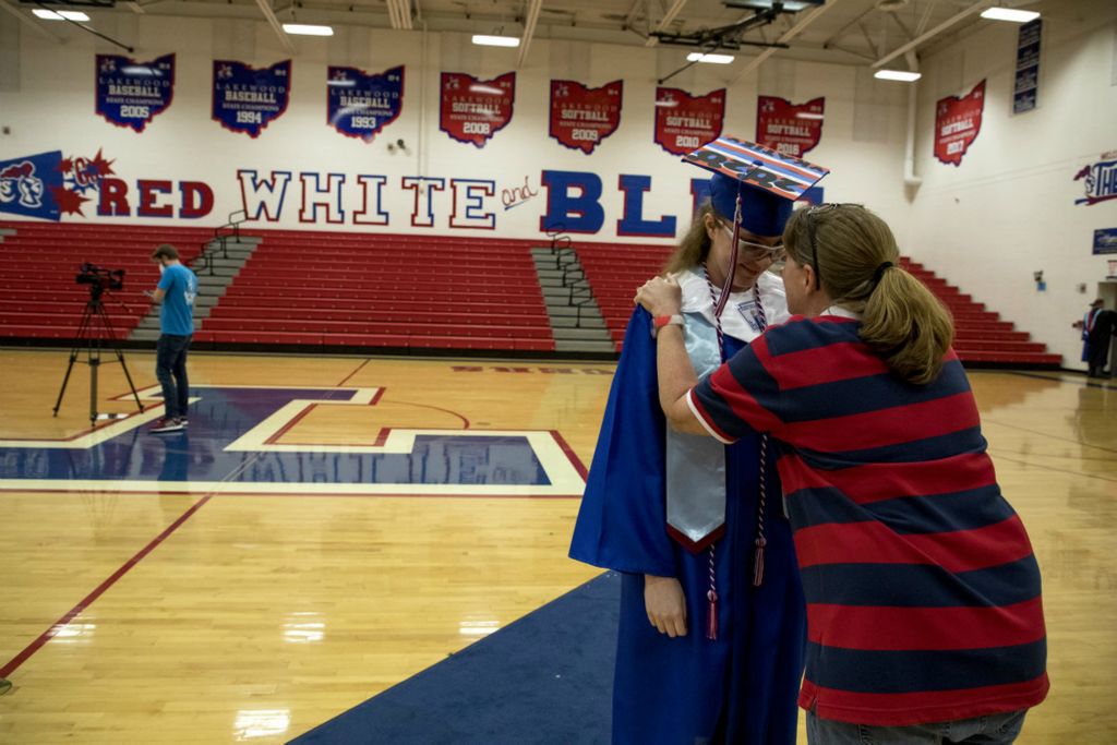 First Place, George S. Smallsreed Jr. Photographer of the Year - Small Market - Jessica Phelps / Newark AdvocateKatie Chittum, now a Lakewood graduate, talks with her mom after readjusting her cap and giving the invocation during her graduation, May 18 2020. Due to the pandemic students had to sign up for a time slot and walk through an empty gym with only four family members in attendee to cheer them. The ceremony was recored and played online when their ceremony would have been held.