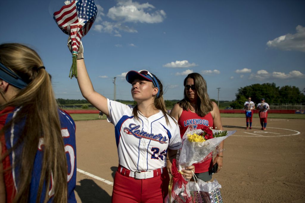 First Place, George S. Smallsreed Jr. Photographer of the Year - Small Market - Jessica Phelps / Newark AdvocateLakewood senior, Kaitlyn Vaubel raises flowers she received at senior night after being honored with her parents and other seniors June 30, 2020. The varsity team then played the JV team for one final game.