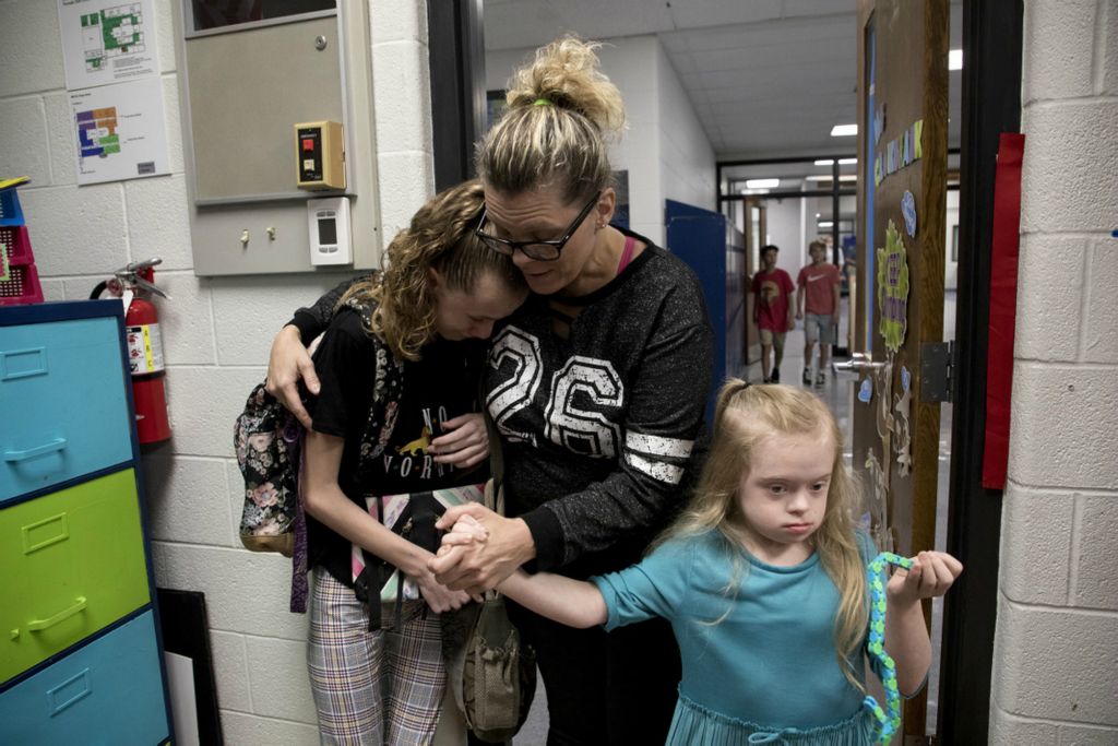 First Place, George S. Smallsreed Jr. Photographer of the Year - Small Market - Jessica Phelps / Newark AdvocateLeah Hrebluk is a single mom raising two daughters with special needs.  Her children are the reasons why Leah continues to advocate, and the reason why she views life through a different lens. A positive one. “We're still living the life. We may not be able to do as much as some people do,” Leah said. “But we take what we can. We do it. And then when enough is enough, we go back home and we rest.”Leah Hrebluk holds onto her daughter, Sophia, and coaxes her into her new classroom on the first day of school in Granville August 21, 2019. Sophia was nervous about starting 7th grade in a new school away from the teachers and friends she had made while at Licking Valley.