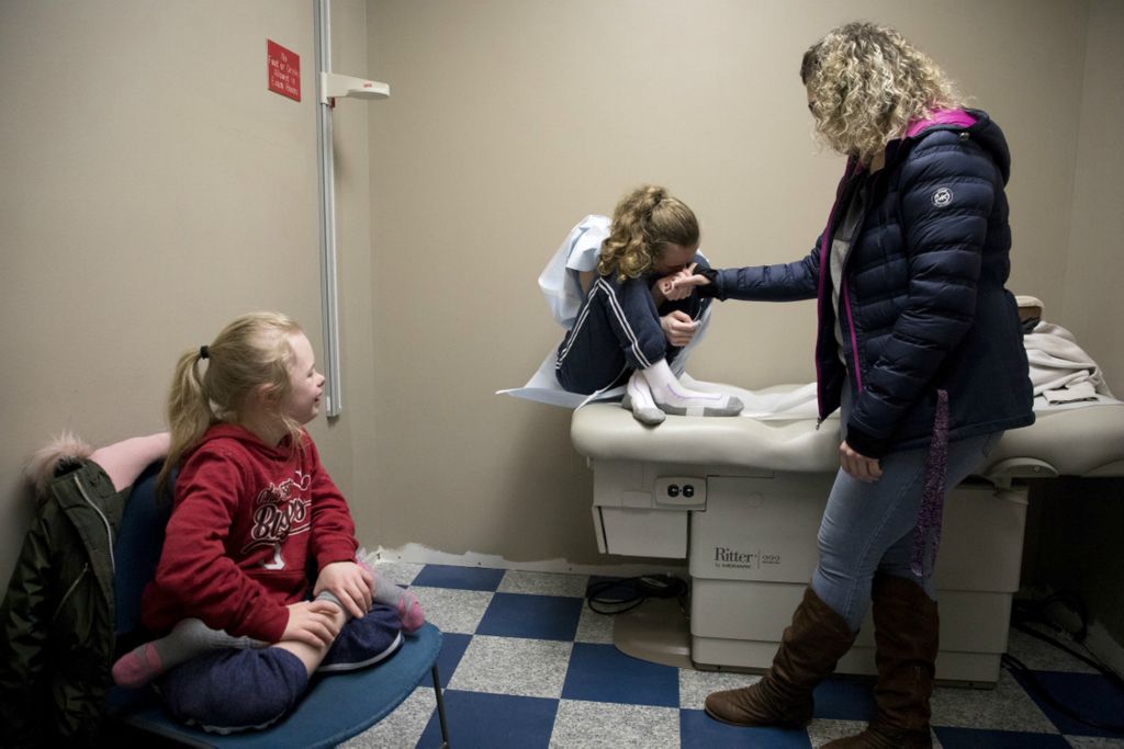 First Place, George S. Smallsreed Jr. Photographer of the Year - Small Market - Jessica Phelps / Newark AdvocateLeah holds her daughter Sophia in the doctors office, January 7, 2020, comforting her before she has to get a shot. Sophia was extremely nervous about receiving a shot that day but eventually faced her fear with courage, the way she always does. Born with Cerebral Palsy Sophia has had to fight for everything in life. 