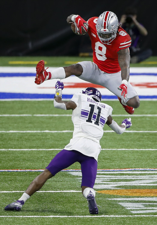Third Place, Ron Kuntz Sports Photographer of the Year - Adam Cairns / The Columbus DispatchOhio State Buckeyes running back Trey Sermon (8) hurdles Northwestern Wildcats defensive back A.J. Hampton (11) during the second quarter of the Big Ten Championship football game at Lucas Oil Stadium in Indianapolis on Saturday, Dec. 19, 2020.