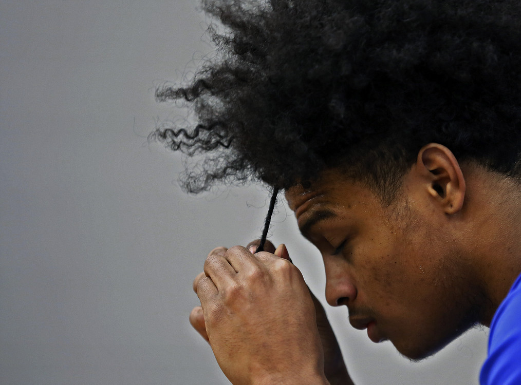 Second Place, Sports Picture Story - Kyle Robertson / The Columbus Dispatch, “Trevell Adams”Trevell Adams takes quick moment to braid his hair on the bench before the start of his game against Whetstone during their second round playoff matchup at South High School in Columbus, Ohio on February 28, 2020. 