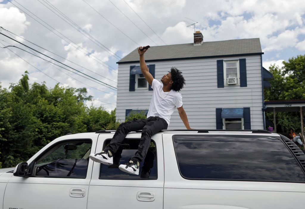 Second Place, Sports Picture Story - Kyle Robertson / The Columbus Dispatch, “Trevell Adams”Columbus South's Trevell Adams celebrates by taking a selfie on top of his fathers car after signing a letter committing to play basketball at Ohio Dominican at his house in Columbus on June 25, 2020.  