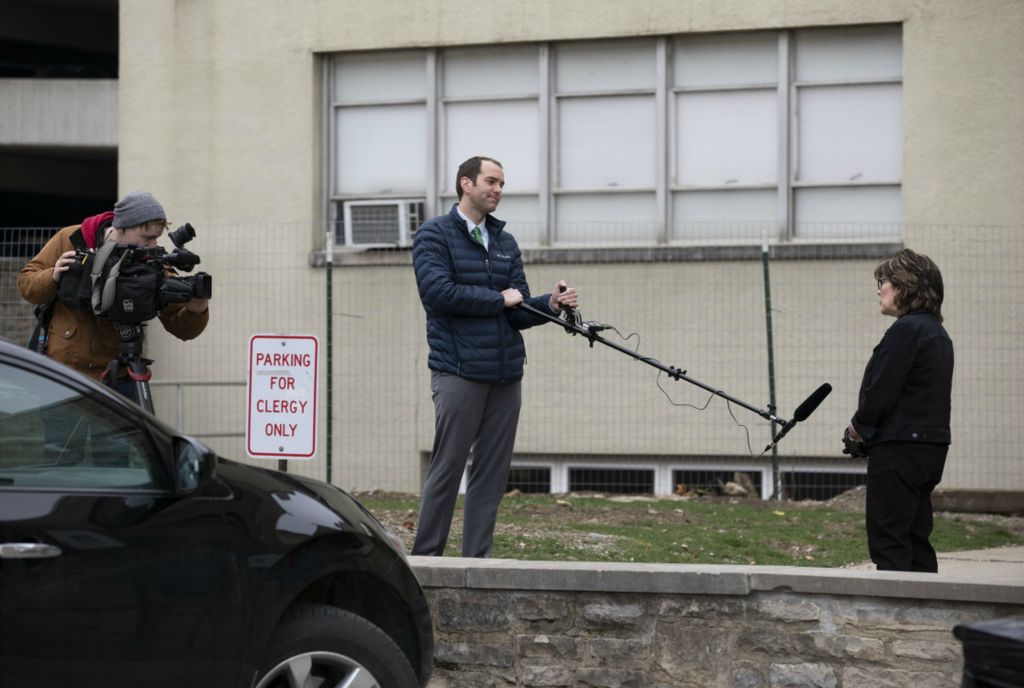 First Place, Team Picture Story - Adam Cairns / The Columbus Dispatch, “Social Distancing”Senior pastor Virginia Lohmann Bauman is interviewed by WSYX reporter Ben Garbarek and photographer Dennis Spronck outside St. John's Church in Columbus on Wednesday, March 18, 2020. The crew used a boom mic to keep a safe distance due to health concerns related to coronavirus. 