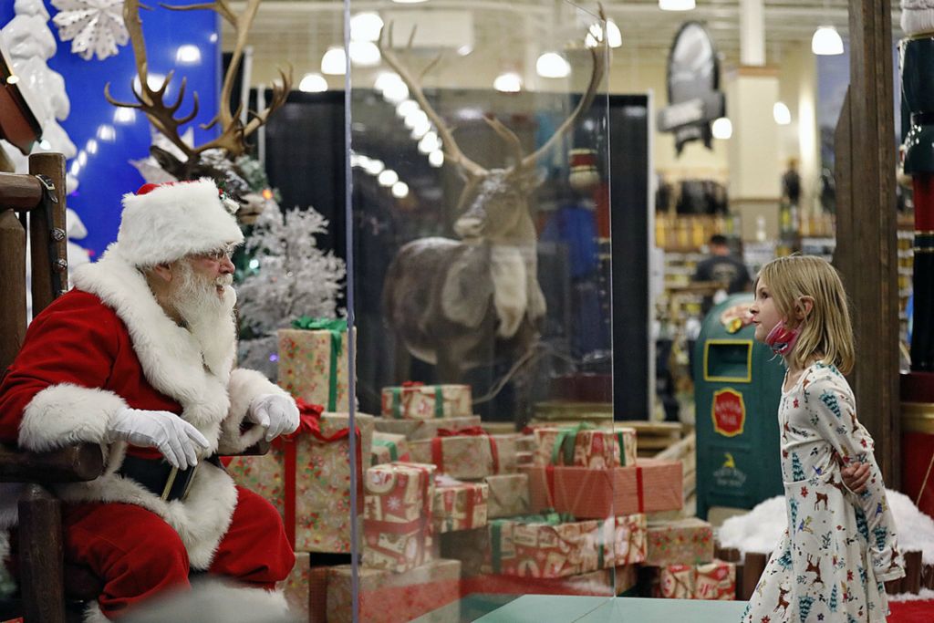 First Place, Team Picture Story - Kyle Robertson / The Columbus Dispatch, “Social Distancing”Stephanie Gaskill, 7, of Cambridge speaks to Santa through a "magic shield" at Cabela's in Columbus on November 10, 2020. Cabela's is only allowing 25 appointments each night to see Santa. 