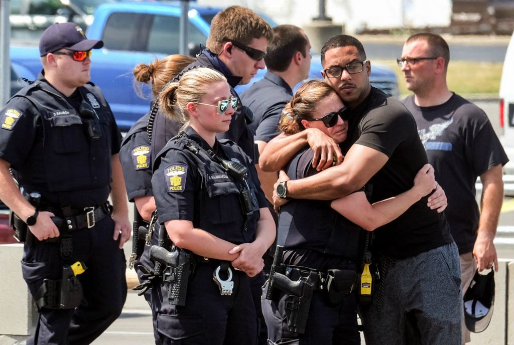 First Place, Team Picture Story - Jeremy Wadsworth / The Blade, “Officer Killed”Toledo Police officers gather in the Home Depot parking lot to mourn the loss of Officer  Anthony Dia.