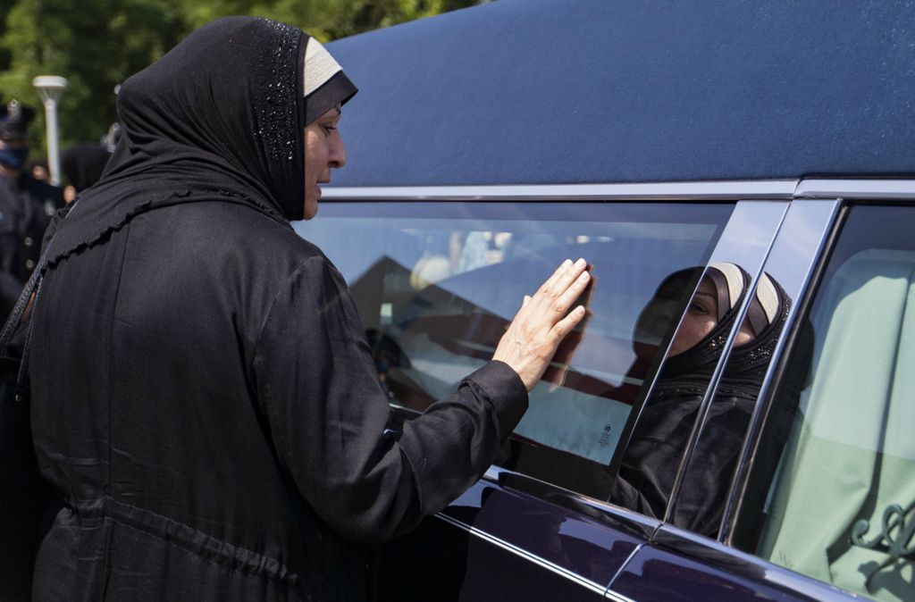 First Place, Team Picture Story - Rebecca Benson / The Blade, “Officer Killed”Amal Younes puts her hand on the hearse carrying slain Toledo police Officer Anthony Dia at The University of Toledo