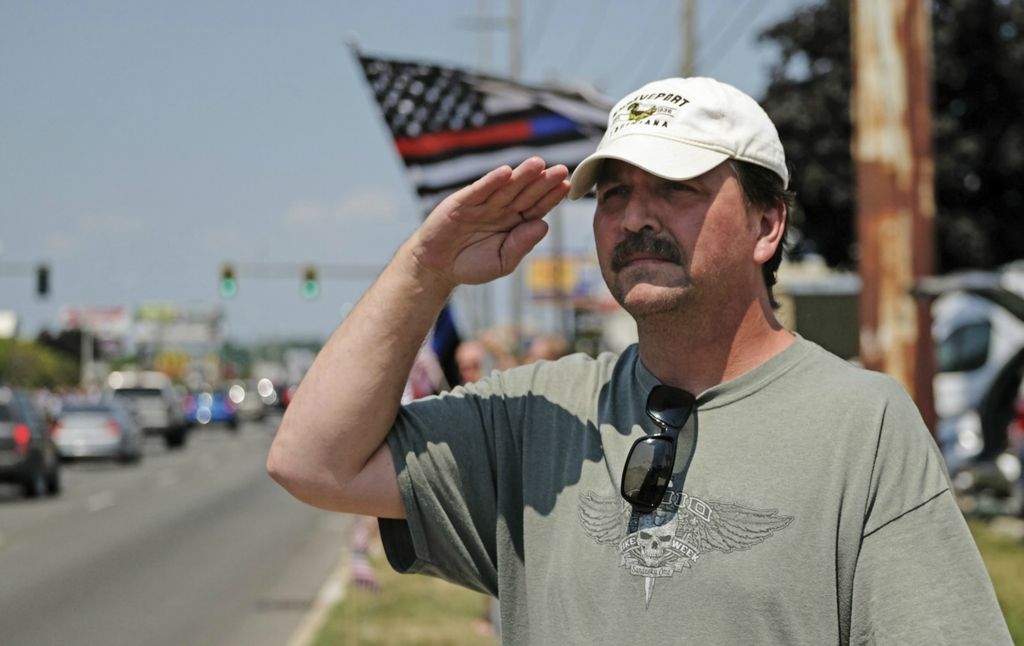First Place, Team Picture Story - Jetta Fraser / The Blade, “Officer Killed”Mark Bolfa of Toledo salutes as the funeral cortege for Officer Anthony Dia passeson Monroe Street.