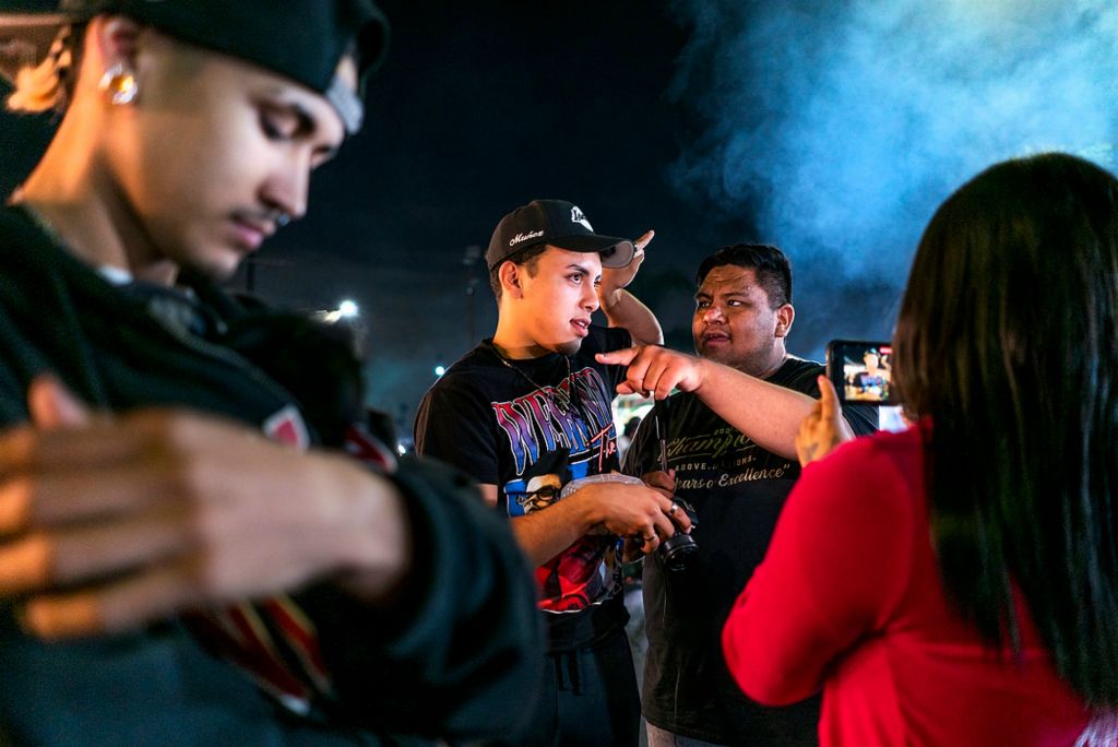 First place, Chuck Scott Student Photographer of the Year - Erin Burk / Ohio UniversityLeft to right: Edwin Grenland cradles his new puppy, Dior, while Manny Perez and famous TikToker Leo Gonzalez discuss the location of a stall in front of Vanessa Mendoza, who is filming them on her phone.Every night in Lincoln Heights, the Avenue 26 street market sets up shop and provides LA with top-notch street food, a commodity that has been sorely missed since the beginning of the pandemic. Its sudden and explosive growth in popularity can be attributed to TikTokers like Gonzalez making short videos about it and giving it more exposure. 