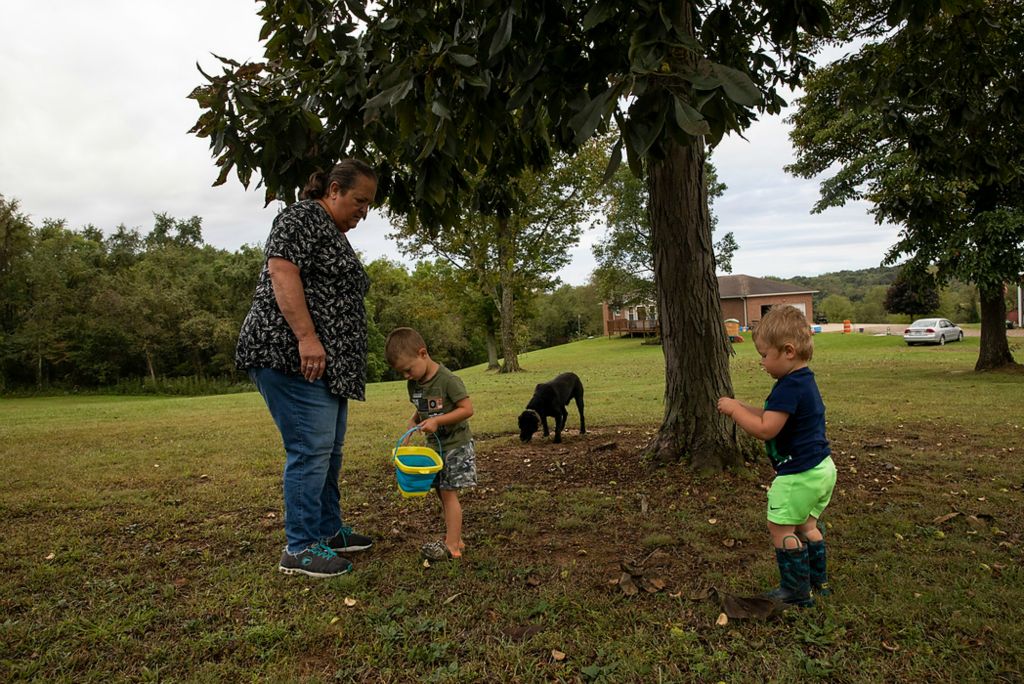 Second place, Chuck Scott Student Photographer of the Year - Chris Day / Ohio UniversityDanita McLaughlin watches as Silas and Mangus Shaulis look for hickory seeds with their dog Chief outside of her daughter Melanie's home in Albany, Ohio, on Sept. 23, 2021. The boys love to play outside and it's often a challenge for Danita to keep any clothes they wear clean for more than a few minutes. "Noise, wheels and mud are their favorite things," she said.