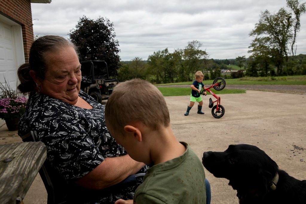 Second place, Chuck Scott Student Photographer of the Year - Chris Day / Ohio UniversityDanita McLaughlin talks to Silas Shaulis as Mangus Shaulis plays with his bike and their dog Chief looks on. The boys will race around the yard on their bikes and small four wheelers with Danita attempting to keep them from the mud and being there with a kind word and a hug if one should fall down.