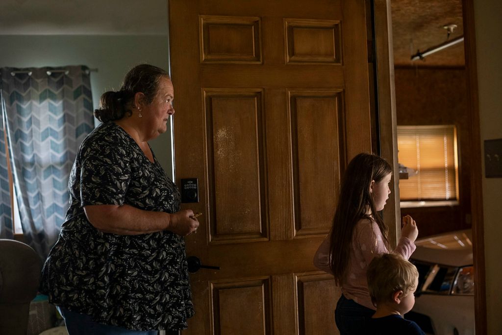 Second place, Chuck Scott Student Photographer of the Year - Chris Day / Ohio UniversityDanita McLaughlin, Kennedy Smith, 7, and Mangus Shaulis look out the garage door to see if Kennedy's father has arrived to pick up her and her brother Kain on Sept. 23, 2021. When they were little, Danita used to watch Kennedy and Kain during the day while her older daughter Miranda Smith and her son-in-law Josh Smith worked. Now, Kennedy and her brother get off the bus at their Aunt Melanie's house three days a week and join Mangus and Silas in being watched by Danita before one of their parents picks them up.