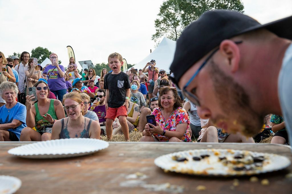 Second place, Chuck Scott Student Photographer of the Year - Chris Day / Ohio UniversityRyan Gartley competes in a pawpaw eating contest as attendees watch and cheer during the 23rd Annual Ohio Pawpaw Festival in Albany, Ohio, on Saturday, September 18, 2021. Gartley, who ultimately won the competition, said this is his second pawpaw contest he's taken part in. His main strategy is to get the seeds off to the sides as much as possible while he's eating the remainder of the fruit.