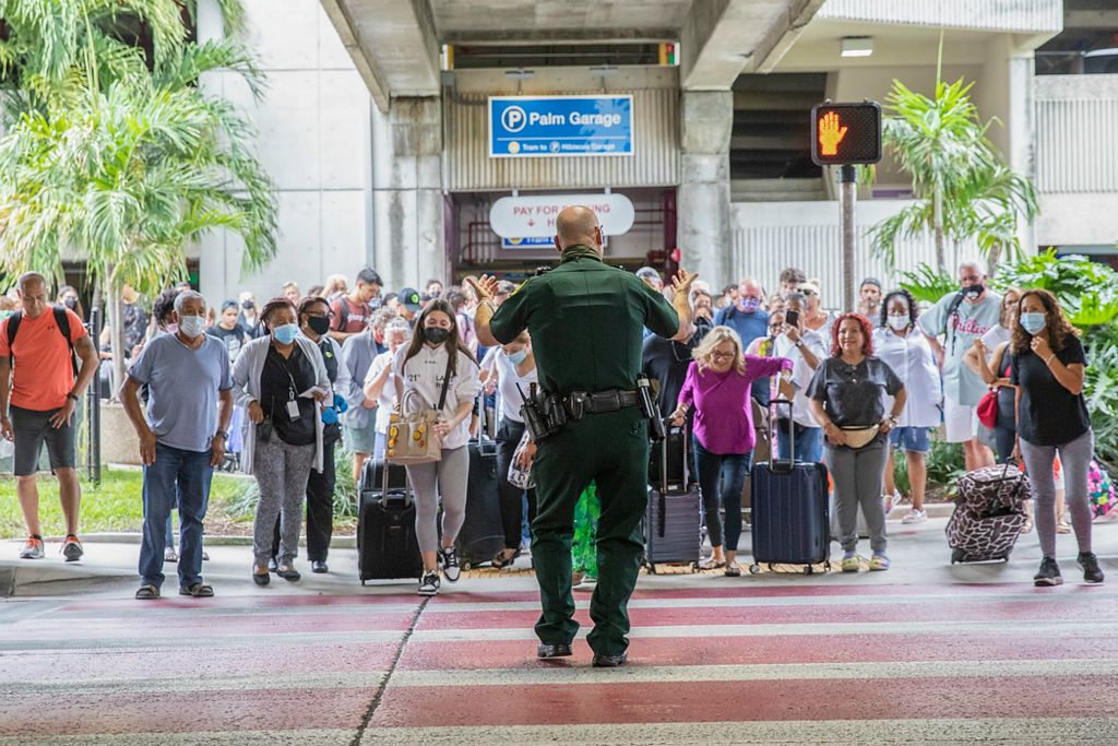 Second place, Chuck Scott Student Photographer of the Year - Chris Day / Ohio UniversityBroward County Sheriff’s Deputy Christopher Rossi signals to passengers that Terminal 3 is safe to enter at Fort Lauderdale-Hollywood International Airport after officials received a bomb threat on Saturday morning, July 10, 2021.