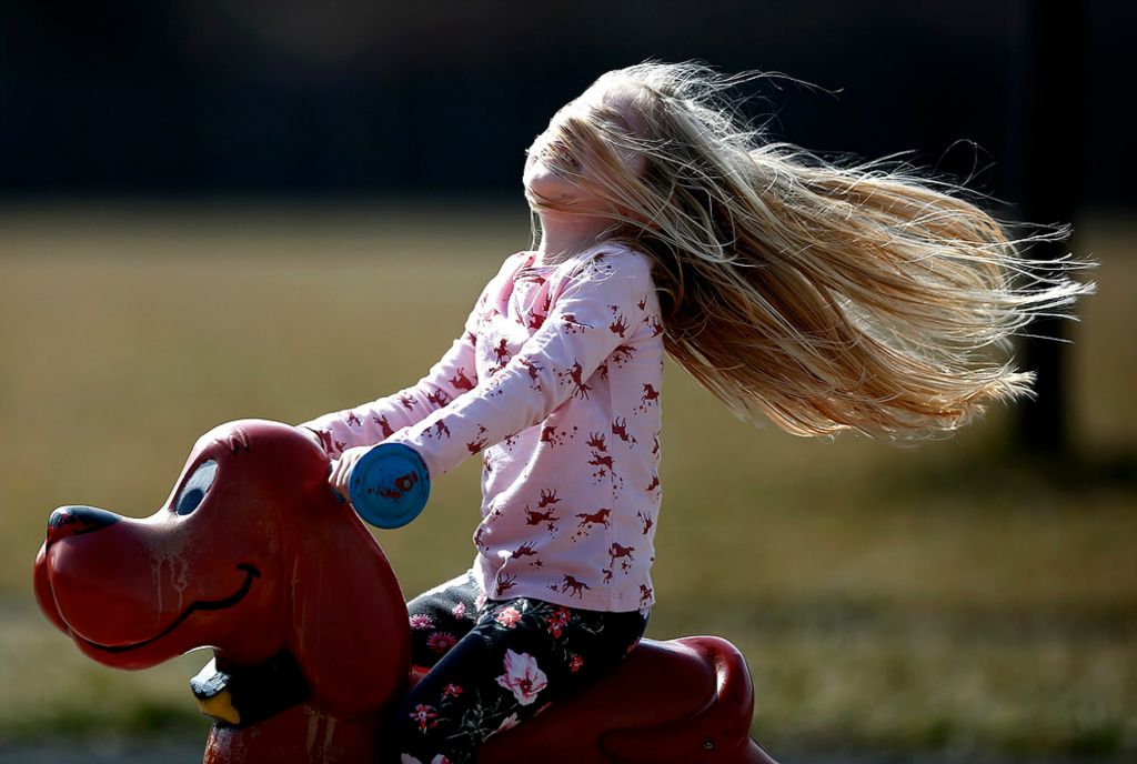 Third place, Feature - Fred Squillante / The Columbus Dispatch, "Windy Day"Katherine Flanagan, 3, rides into the wind as she rocks on Clifford the Big Red Dog on the playground at Arbor Ridge Park in Powell. Her grandparents, Ray and Cindy Flanagan, brought Katherine and her brother, Lockland Flanagan, 5, to the park to fly a kite. Cindy said they had been waiting for the weather to be warm and windy enough to fly the kite. The kids lost interest in the kite and went to play on the playgrounrd.