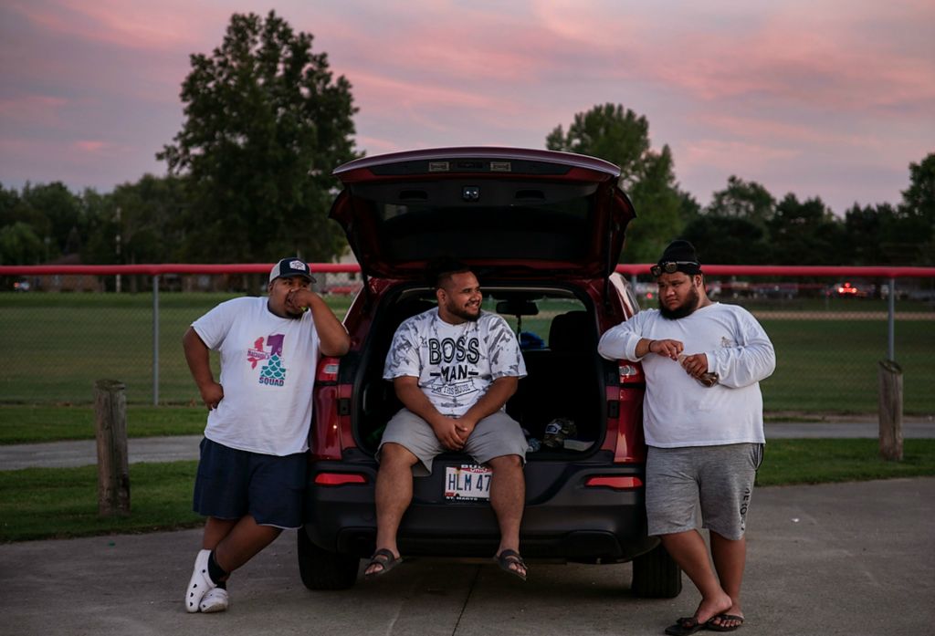 First place, Feature Picture Story - Erin Burk / Ohio University, "Medicare"Michael Joash, center, hangs out with his brother, Isshi Joash, right, and his friend, Joseph Momita, left, after watching a volleyball tournament in Celina, Ohio on September 18, 2021. "It's just me returning the favor," says Michael Joash, on caring for his aging father, Jay. "It's just our duties to return the care and love he has given us all these years." The responsibility of caring for older generations is big, and one commonly shouldered throughout the Marshallese community.