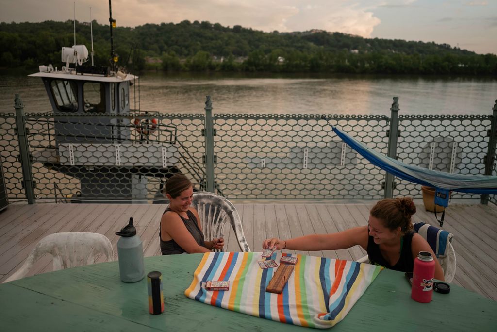 Second place, Feature Picture Story - Joshua A. Bickel / The Columbus Dispatch, "Our Rivers’ Keepers"After dinner, Rachel Loomis, left, and Callie Schaser (right) laugh while playing a game of cribbage on the house barge’s roof deck. The kind of 24/7 work, live and play atmosphere that defines life on the barge takes a certain kind of person. “You really got to be a team player out here, like, you're not in this for yourself, you're in this for this type of work,” Loomis said.