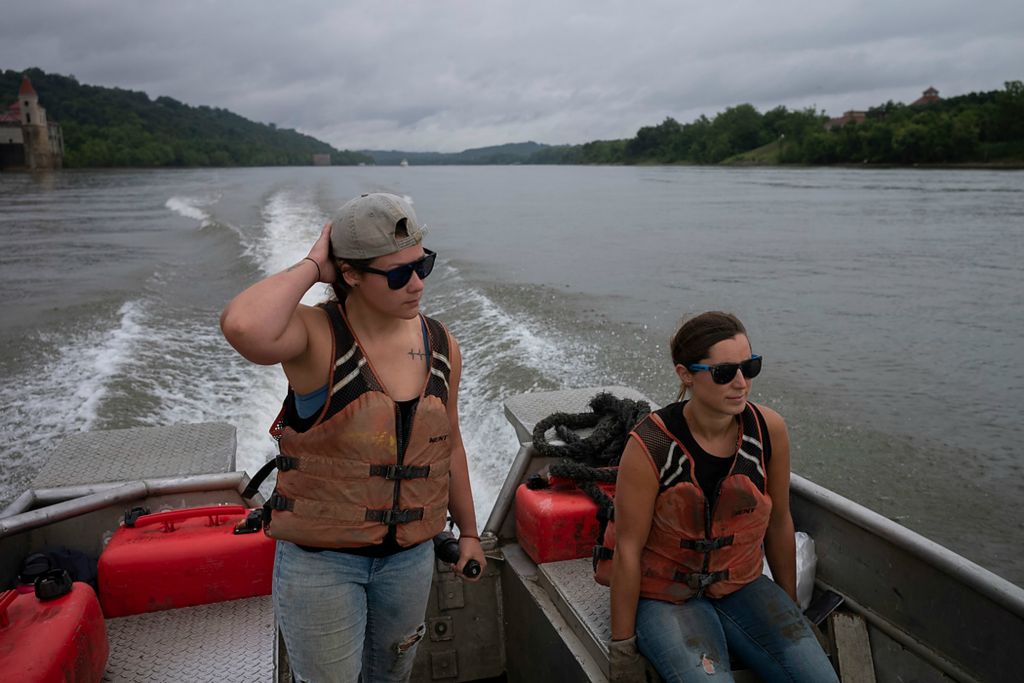 Second place, Feature Picture Story - Joshua A. Bickel / The Columbus Dispatch, "Our Rivers’ Keepers"Callie Schafer (left) holds onto her hat while navigating down the Ohio River with Rachel Loomis (right) as the pair looks for a spot to do some clean-up work. Schafer recognizes that for everything the crew understands about garbage and the river there are many other people who are unaware of the depth of the pollution. “If you never get out of your small town or you you're not near any water, how are you going to know?” she said. “I'd be ignorant to think no matter what I'm doing it is making an impact or has an effect somewhere else — negatively, positively and everywhere in between. So that's why I just really try to be present.”