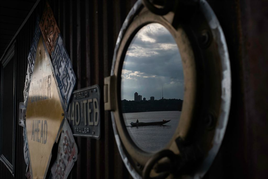 Second place, Feature Picture Story - Joshua A. Bickel / The Columbus Dispatch, "Our Rivers’ Keepers"After working for the day, Rachel Loomis is reflected in a window on the barge as she cleans out a Jon boat, a small vessel that the crew uses to navigate to clean-up sites.