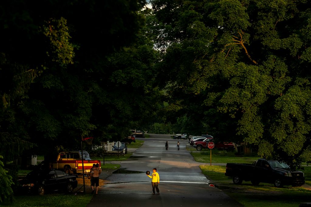 Third place, Feature Picture Story - Meg Vogel / The Cincinnati Enquirer, "Vaccine Hesitancy"A boy plays basketball outside his home down the street from a temporary vaccination clinic at the Laurel Community Center on June 7, 2021 in Laurel, Indiana. Franklin County has 23,000 residents. Fear, distrust and politics still dominate conversations about the vaccine among Franklin County's residents. The skeptics say they worry about the speed of vaccine development and the uncertainty of long-term health effects. Some repeat disproven conspiracy theories involving infertility, aborted fetal tissue and plots against former President Donald Trump.