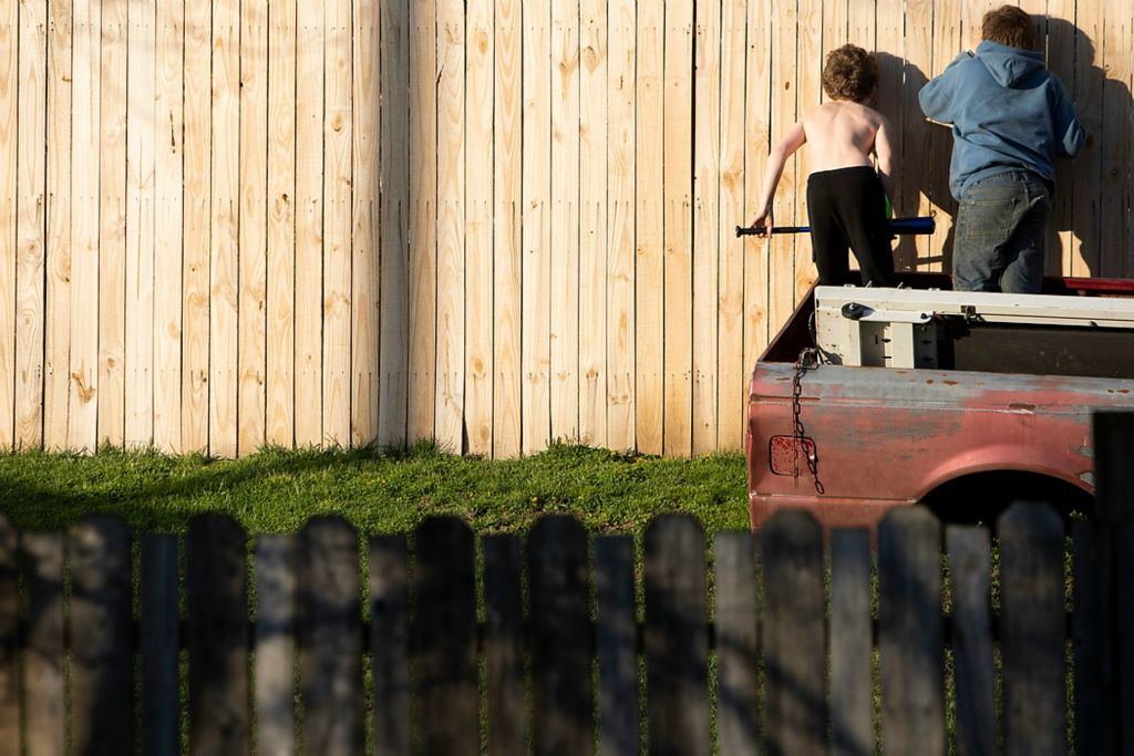 Second place, News Picture Story - Chris Day / Ohio University, "New Marshfield, Ohio"Jeremiah "Miah" McDowell, 9, and Trace Eblin, 11, peer through a fence in the backyard of Miah's grandfather's home in New Marshfield on April 4, 2021.