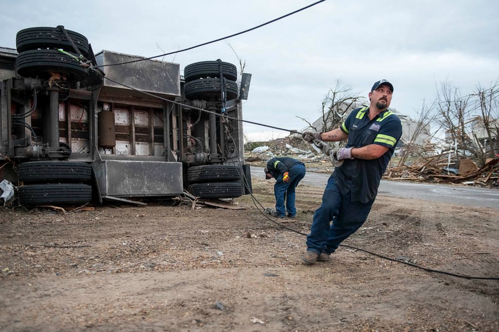 Award of Excellence, News Picture Story -  / , "Tornado"Brandon Thomas of Mayfield pulls a metal towing cable to the back of the towing truck on Dec. 15, 2021. Thomas and his coworker Lane Fuqua have spent the days after the tornado towing vehicles that have tipped over.