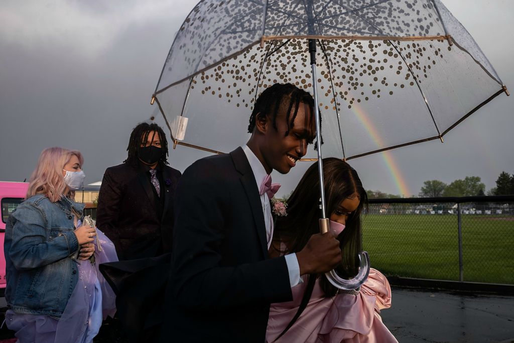 First place, Photographer of the Year - Large Market - Joshua A. Bickel / The Columbus DispatchKeith Hodge (center) holds an umbrella for his date, Sienna Pritchard, as they arrive at the football field for their outdoor Prom on May 7, 2021 at Whitehall-Yearling High School in Whitehall, Ohio. It was the first large in-person event for these young people after prom was cancelled the prior year because of the COVID-19 pandemic, and a return to a sense of normalcy. Also with them are classmates (from left) Brooklyn Daye and Peter Rankin.