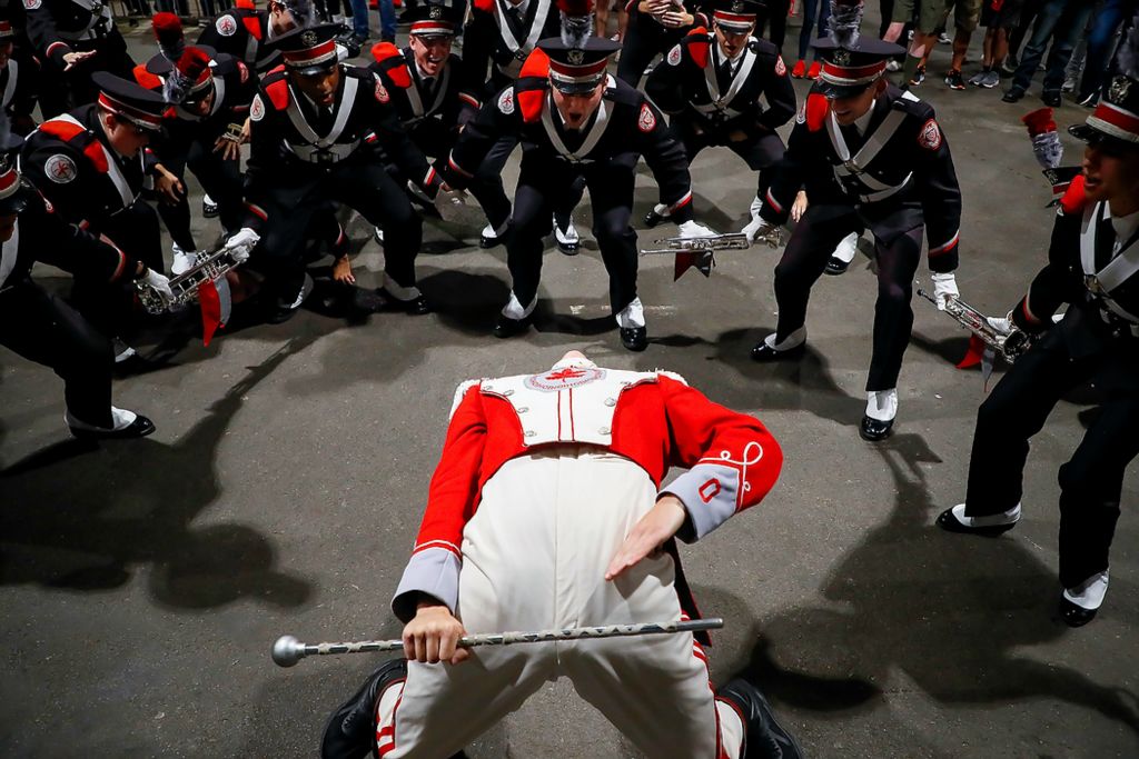 First place, Photographer of the Year - Large Market - Joshua A. Bickel / The Columbus DispatchMembers of the Ohio State University Marching Band's trumpet section cheer as drum major Austin Bowman does his third signature backbend during the "Three Knocks" tradition signaling the arrival of the band to the stadium. During this tradition, Bowman bends backwards until the plume in his hat touches the ground, then bangs on a metal plate affixed to the wall in front of him. After doing that three times, the band lines up in formation, ready for their pregame performance.