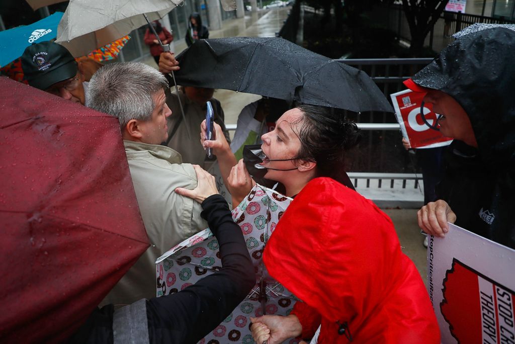 First place, Photographer of the Year - Large Market - Joshua A. Bickel / The Columbus DispatchSupporters against Critical Race Theory try to block a woman, center, as she yells, "Go home, racist!" to Republican U.S. Senate candidate Josh Mandel as he speaks during a protest against Critical Race Theory curriculum in Ohio schools on Sept. 21, 2021 outside the State Board of Education in Columbus, Ohio.