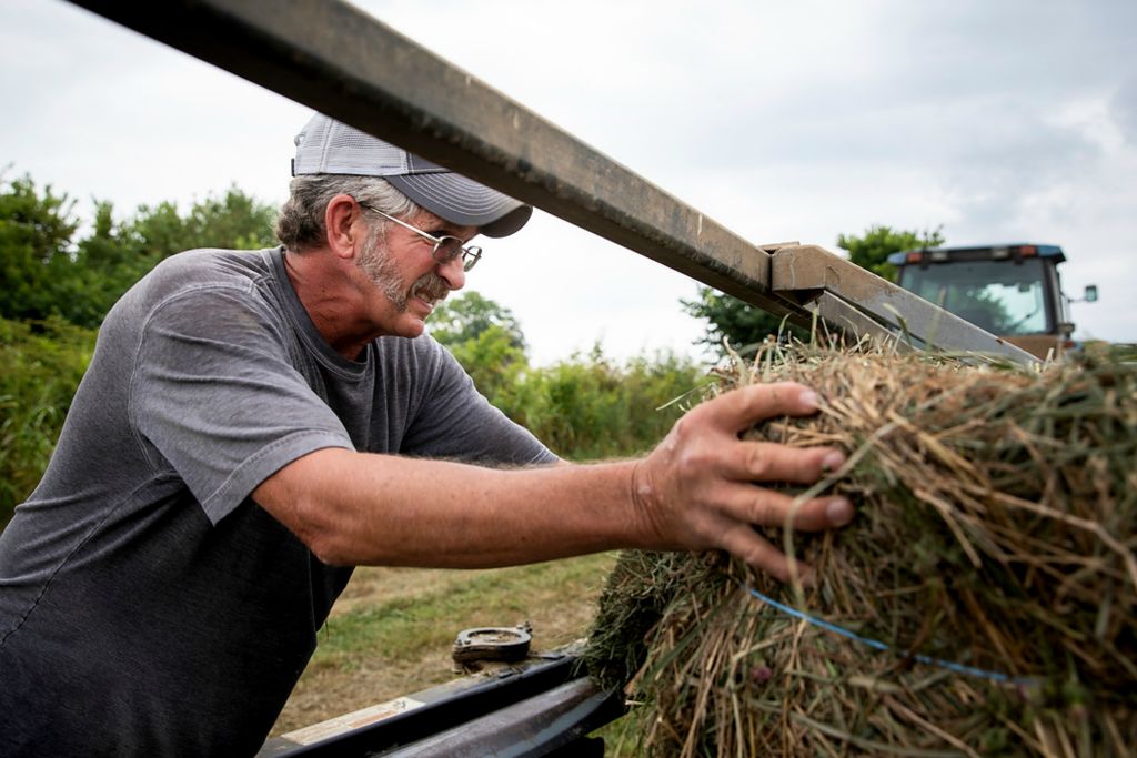 Second place, Photographer of the Year - Large Market - Meg Vogel / The Cincinnati EnquirerTroy Bradford works on his hay baler on his farm in Harrison County, Ky., on Monday, August 9, 2021. Bradford is leasing 200 acres of his farm for solar panels. "People who have the opportunity to do this now will be the lucky ones," said Bradford.