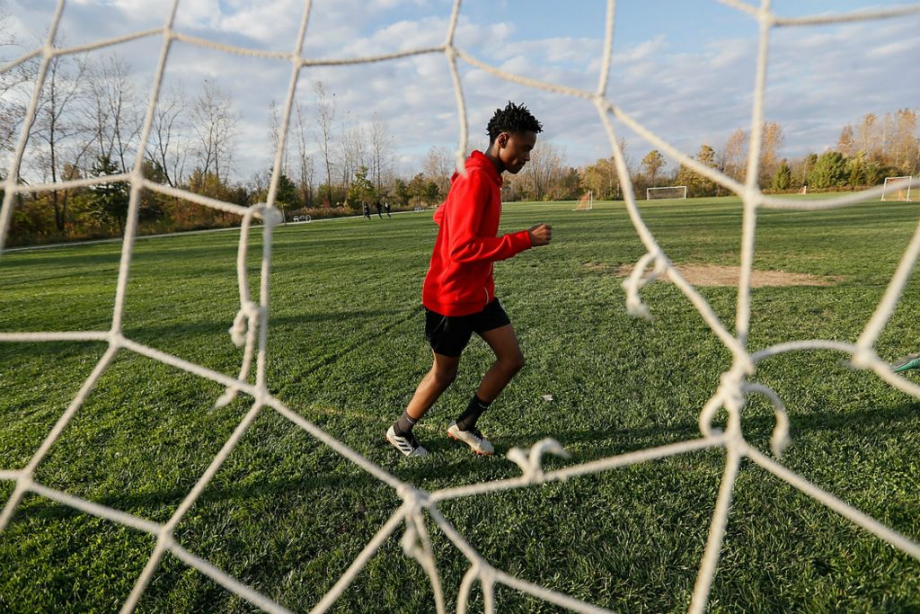 Third place, Photographer of the Year - Large Market - Adam Cairns / The Columbus DispatchAweys Bilal, 14, jogs one of four laps around the soccer fields at Wilson Road Park as he warms up for Hilltop Tigers soccer practice on Nov. 4. The practice would end up being the final outdoor practice of the fall season due to early darkness and colder temperatures.
