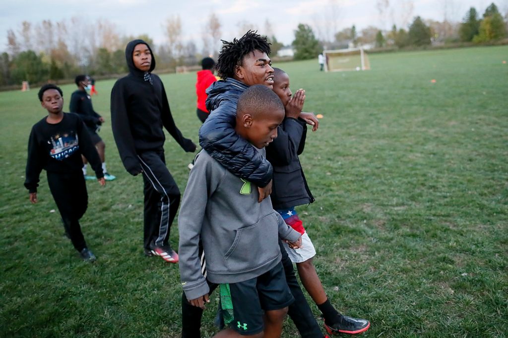 Third place, Photographer of the Year - Large Market - Adam Cairns / The Columbus DispatchSharmarke Abdi, 15, wraps his arms around twins Wencell and Wendell Medina as they finish practicing at Wilson Road Park on Nov. 4. The practice would end up being the final outdoor practice of the fall season due to early darkness and colder temperatures.