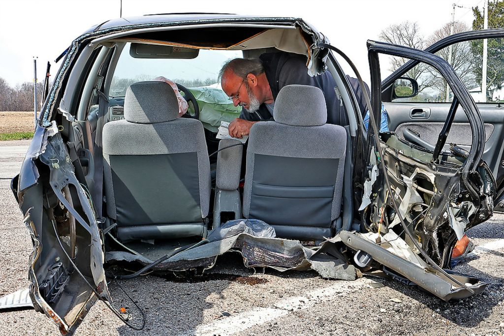 First place, Photographer of the Year - Small Market - Bill Lackey / Springfield News-SunA man gathers a family member's personal items from a car after it was ripped in half by a semi truck on State Route 235 at the intersection with Old Troy Pike in Champaign County.  Remarkably, the driver of the car suffered only non-life threatening injuries and was transported by medic to the hospital. The driver of the semi truck was not injured. 