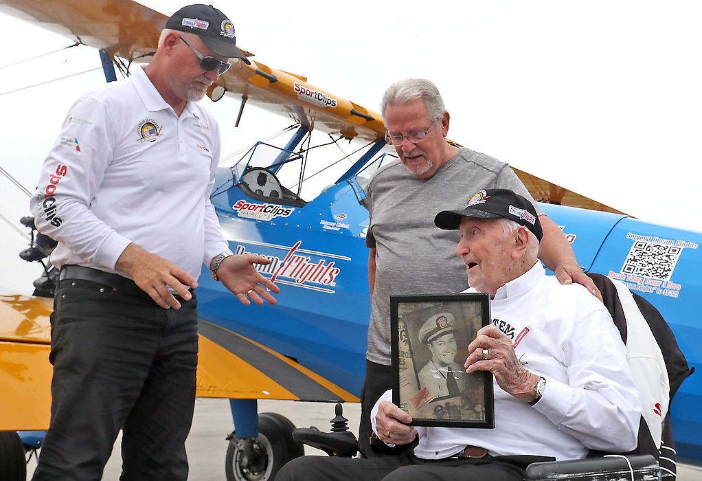 First place, Photographer of the Year - Small Market - Bill Lackey / Springfield News-SunWorld War II veteran Ed Fisher shows Ageless Aviation Dreams Foundation pilot Darryl Fisher a picture of himself when he was a pilot in the NAVY Wednesday following his dream flight in a restored Boeing Stearman biplane at Grimes Field in Urbana. Ed's son, Paul, is at his side. 