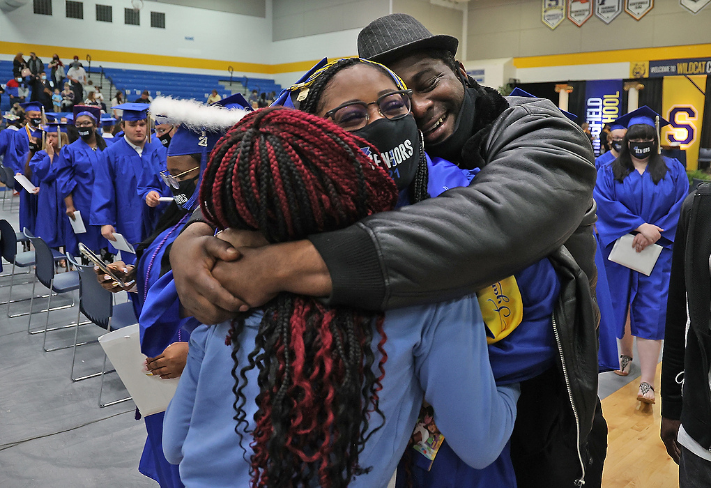 First place, Photographer of the Year - Small Market - Bill Lackey / Springfield News-SunSpringfield High School graduate Tyana Crossley is hugged by her father, Mitchell, and sister, Zayveana, after they rushed the floor as the graduates were marching out of the gymnasium. In an effort to keep crowds small, Springfield held three graduation ceremonies on Saturday. 
