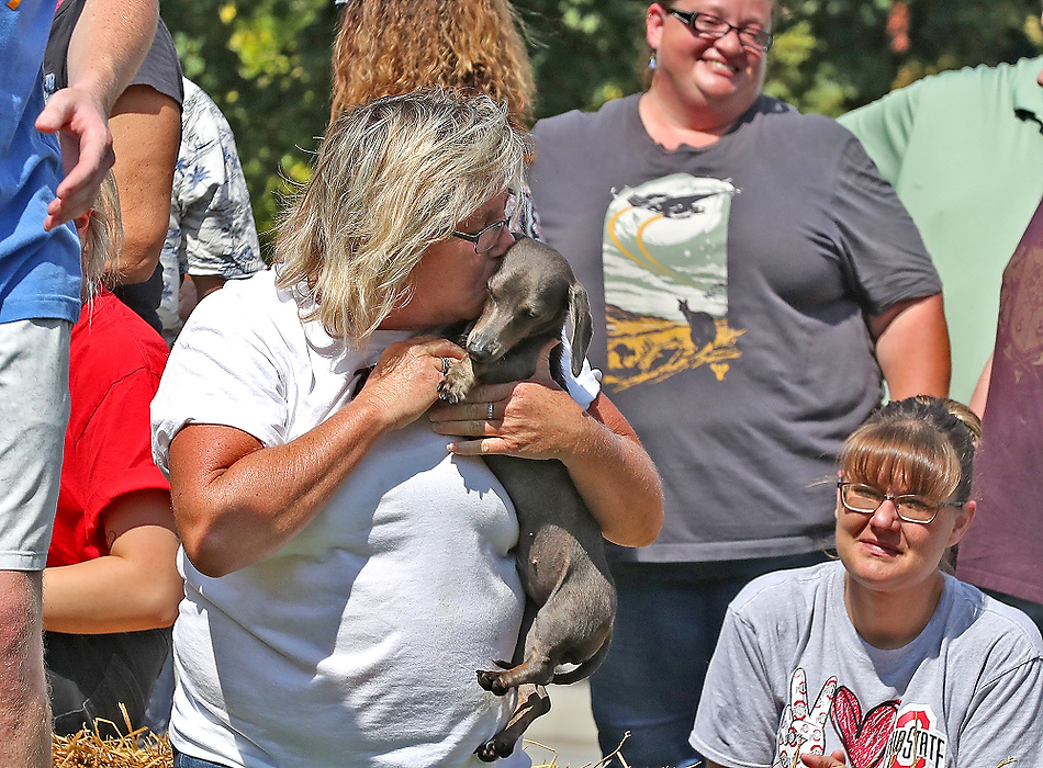 First place, Photographer of the Year - Small Market - Bill Lackey / Springfield News-SunKim Myers, from South Charleston gives "Ruby" a big kiss after she won the championship heat of the 2021 Champion City Wiener Dog Races. 