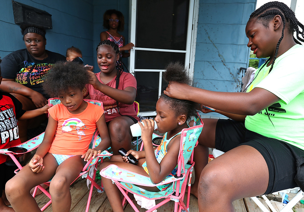 First place, Photographer of the Year - Small Market - Bill Lackey / Springfield News-SunTwin sisters Miracle (left) and Secret Bridgeman comb out the hair of sisters Harmony and Meleody O'Berry on their aunt's front porch after going swimming.