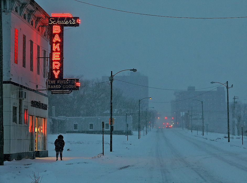 First place, Photographer of the Year - Small Market - Bill Lackey / Springfield News-SunA woman walks under the Schuler's Bakery sign along East Main Street as it glows in the falling snow.